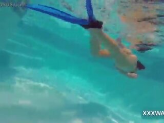 Unggul rambut coklat jalan gadis permen swims di bawah air