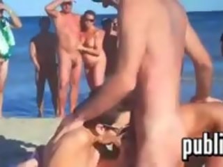 Scambisti avendo divertimento a un spiaggia per un folla